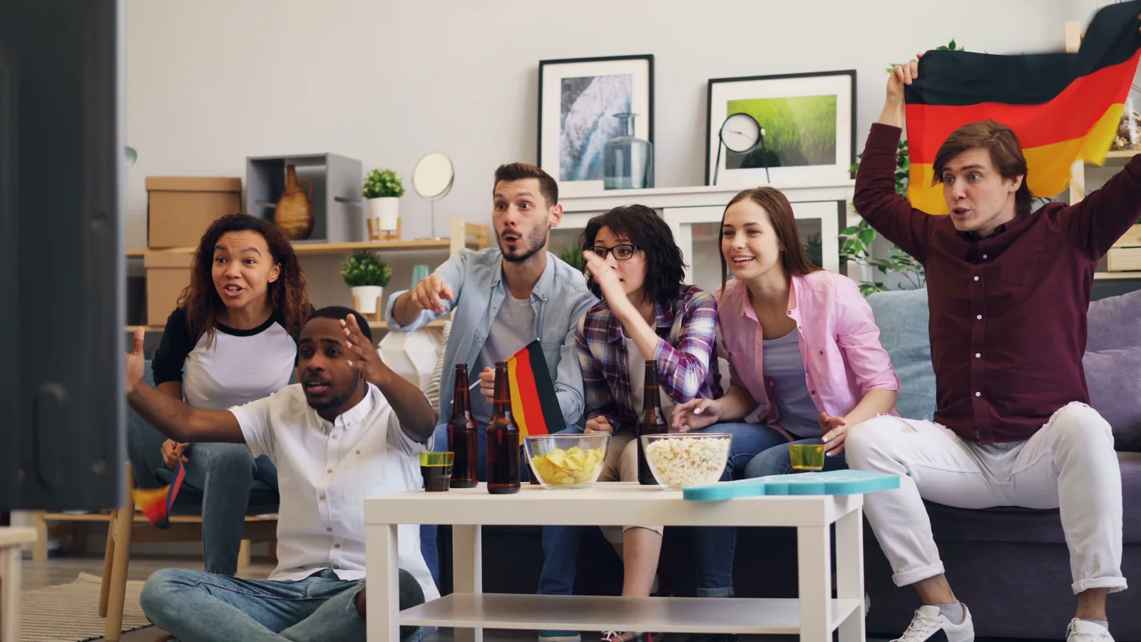 Friends watching a football match together on television