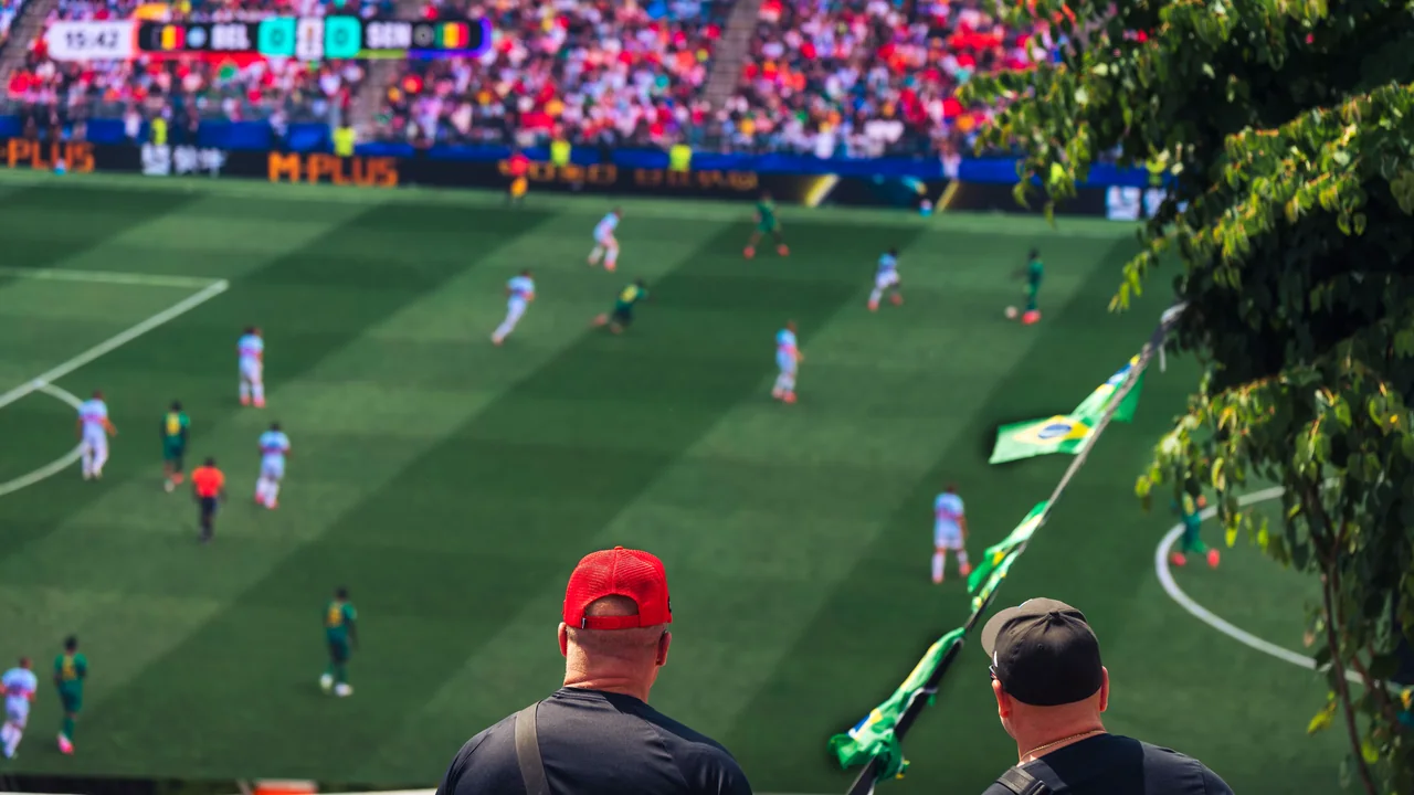 Supporters watching a live football match from the stadium stands