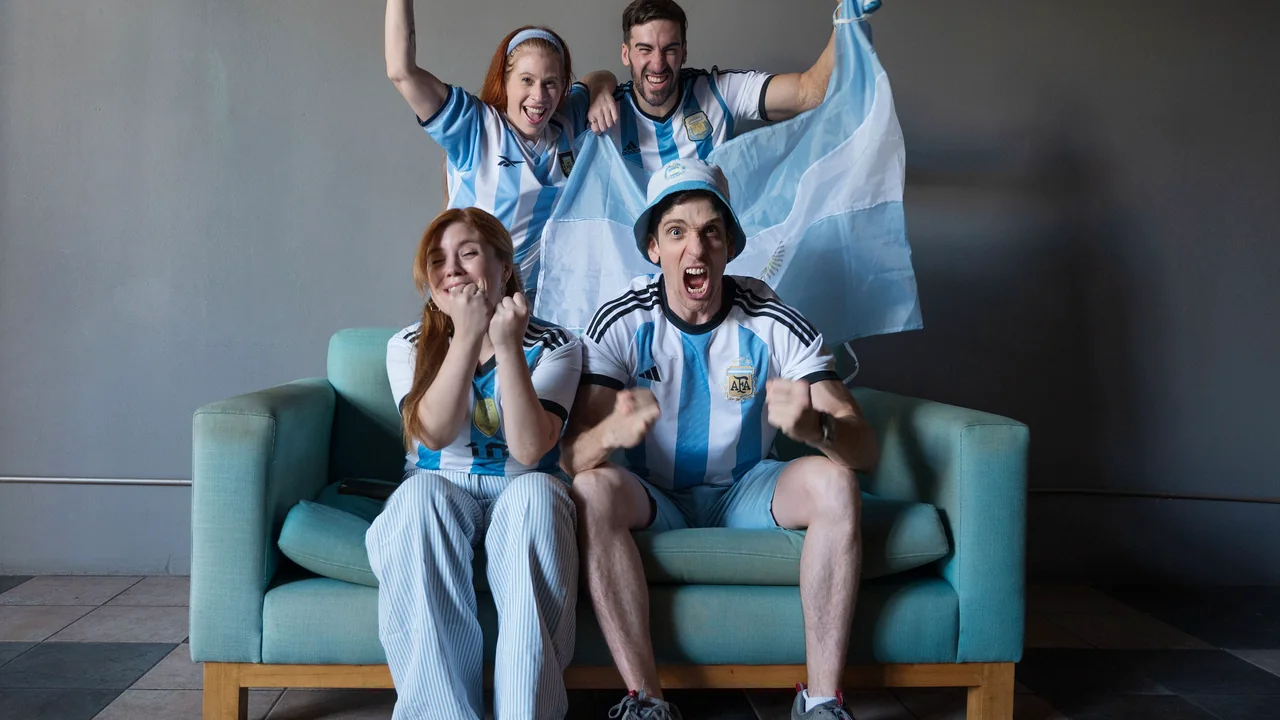 Friends celebrating a football goal in their sitting room